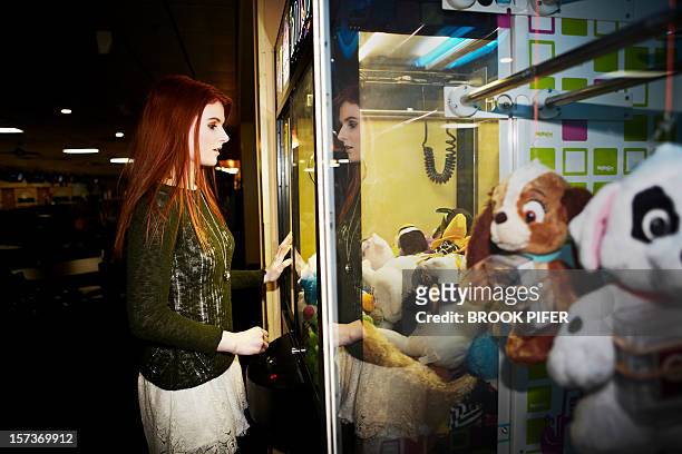 young woman playing arcade game - claw machine stock pictures, royalty-free photos & images
