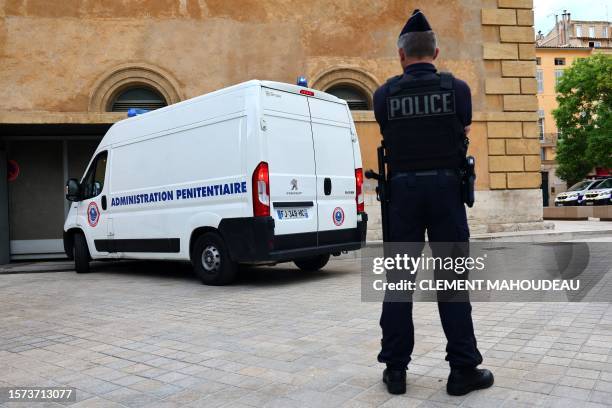 French police officer stands guard as a detained police officer arrives in a penitentiary administration vehicle at the Courtroom in Aix-en-Provence...