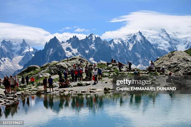 Visitors take a break while hiking in the Lac Blanc area in the Aiguilles Rouges nature reserve which faces Mont Blanc, above Chamonix, Haute-Savoie,...