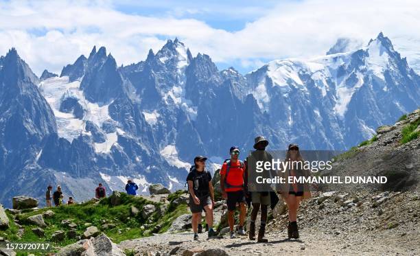 Visitors hike in the Lac Blanc area in the Aiguilles Rouges nature reserve which faces Mont Blanc, above Chamonix, Haute-Savoie, on July 31, 2023....