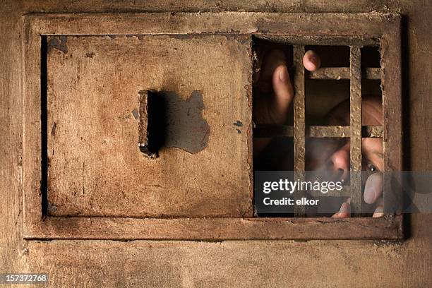 behind the bars - hands on prison bars stock pictures, royalty-free photos & images