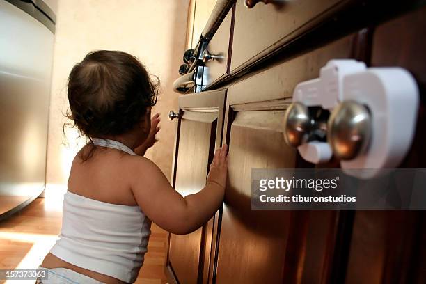 child proofing 3 toddler exploring kitchen - child proofing stock pictures, royalty-free photos & images