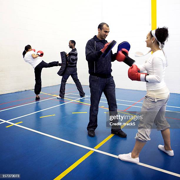 physical education: boxing training lesson with trainers working their athletes - self defence stock pictures, royalty-free photos & images