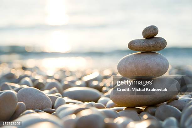 équilibrée des pierres de galets sur la plage pendant le coucher du soleil. - calming images photos et images de collection