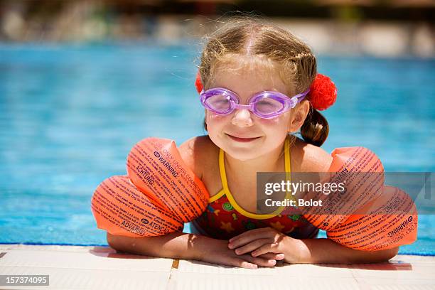 niña en el borde de la piscina - brazaletes acuáticos fotografías e imágenes de stock