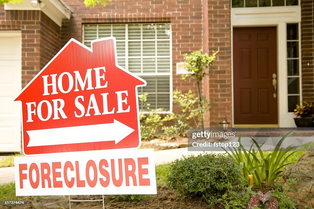 Real Estate Sign in yard of foreclosure house. For sale.