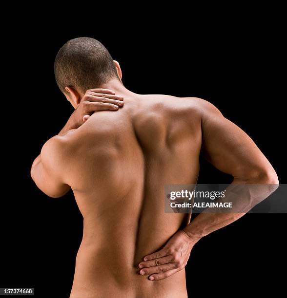 shot from behind of a man clutching his aching back and neck - over shoulder man stockfoto's en -beelden