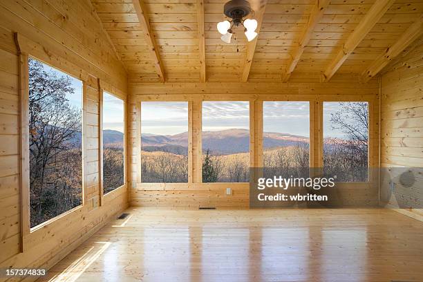 empty wood room with several windows looking out to mountain - wide angle house stock pictures, royalty-free photos & images