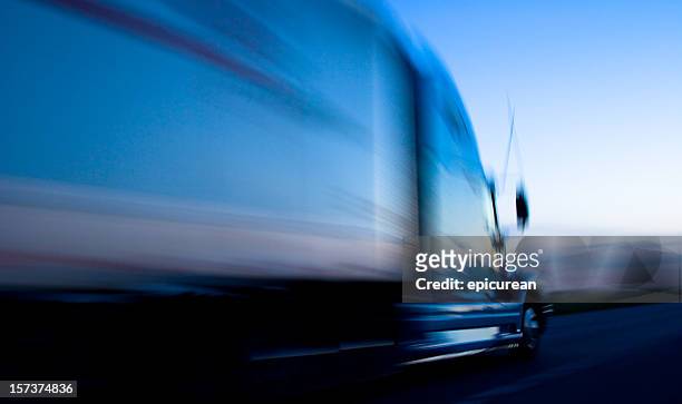 truck speeding down the freeway at dusk - semi truck stockfoto's en -beelden