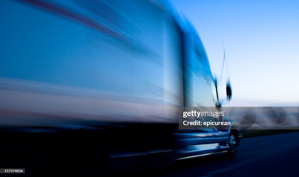 Truck speeding down the freeway at dusk