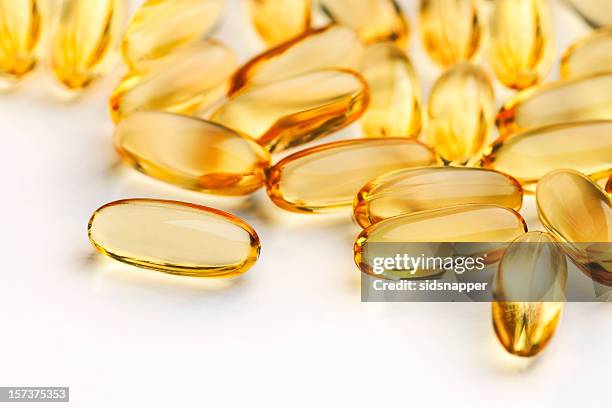 close up of capsules (see below for two other versions) - fish oil stock pictures, royalty-free photos & images