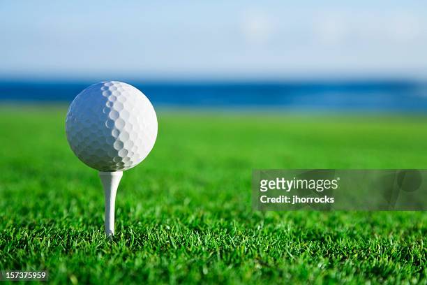 golf ball on tee with ocean view - golf tee stock pictures, royalty-free photos & images