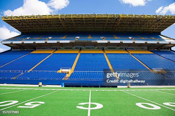 blue chairs with no audience at a football stadium - american football stadium stock pictures, royalty-free photos & images