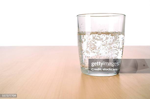 glass of sparkling water on table - carbonated water stock pictures, royalty-free photos & images