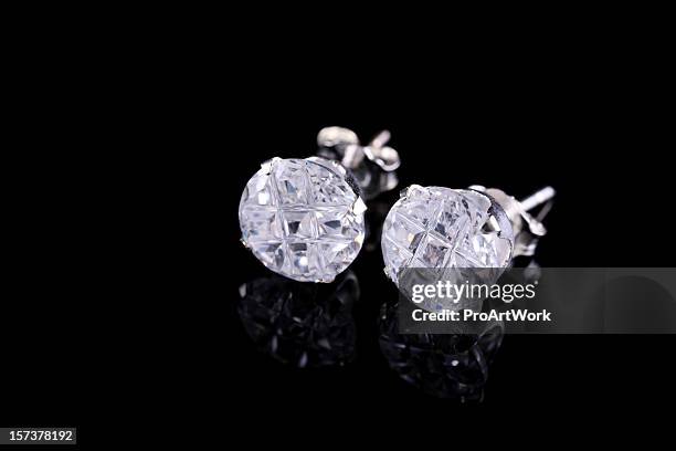 pair of silver diamond stud earrings on a black background - earrings stock pictures, royalty-free photos & images