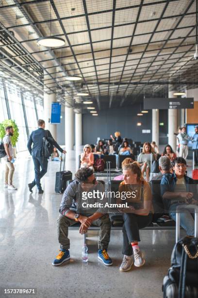 people waiting for their flight - airport departure area stock pictures, royalty-free photos & images