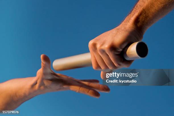 two hands passing relay baton race - beton stock pictures, royalty-free photos & images