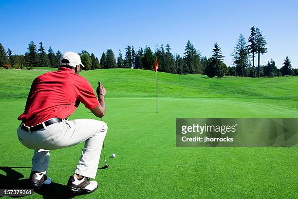 lining up the putt - golf putter stockfoto's en -beelden