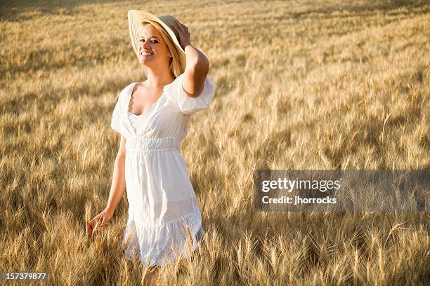 beautiful blonde woman in golden wheat field - girl gold dress stock pictures, royalty-free photos & images