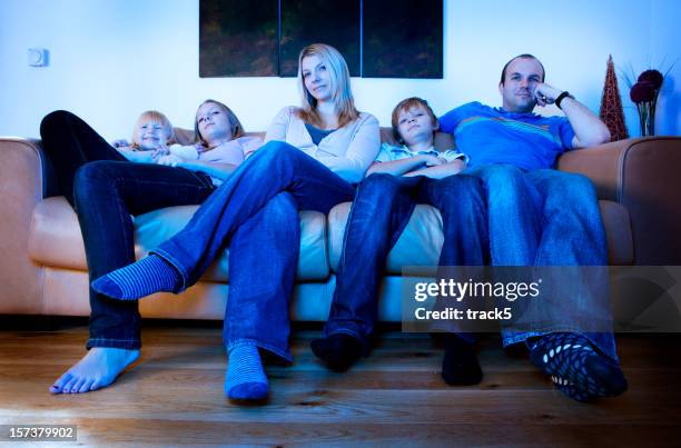 bored, listless faces on a family watching tv - bad posture stock pictures, royalty-free photos & images