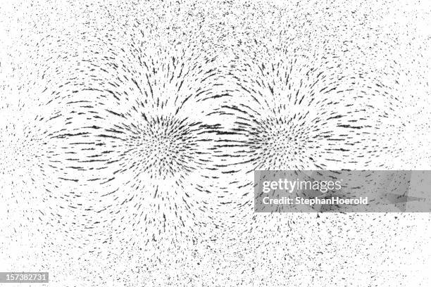 demonstrating magnetic field lines of attracting poles using iron filings - magnetisch veld stockfoto's en -beelden