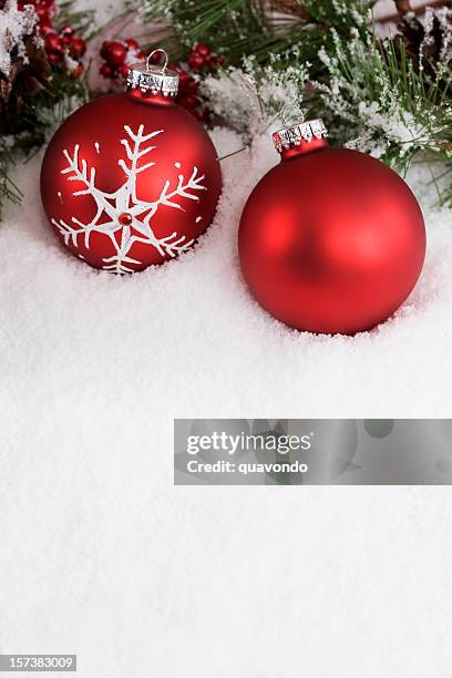 weihnachtsdekoration mit zwei roten ornamenten im schnee, textfreiraum - christmas bauble stock-fotos und bilder