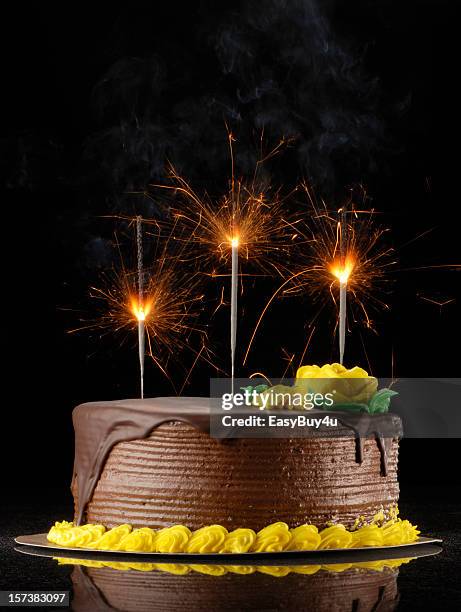 chocolate birthday cake with sparklers on a black background - chocolate birthday cake stock pictures, royalty-free photos & images