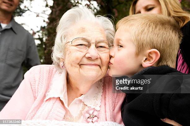 une grand-mère embrassant son petit-fils âgé de 80 ans à la retraite - great grandmother photos et images de collection