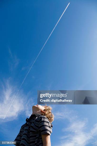 a curly haired young man looking at jet fumes - sky boy stock pictures, royalty-free photos & images
