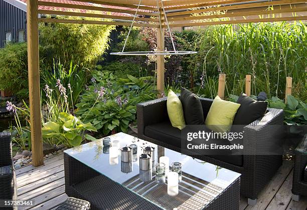 patio with an outdoor wicker sofa and table - cushion stockfoto's en -beelden