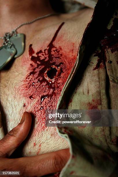 military hombre con máquinas de disparo de pistola de herida en el lado izquierdo del pecho - gunshot wound fotografías e imágenes de stock