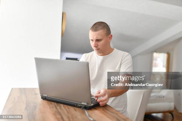 male freelancer turning on laptop to work at home - the short game stock pictures, royalty-free photos & images