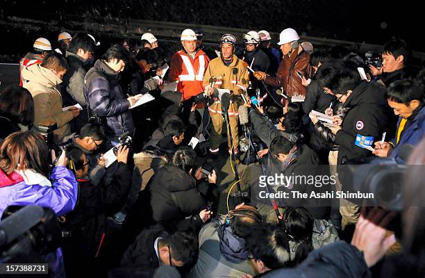 Media reporters surround a head of firefighters during a media briefing outside Sasago Tunnel of the Chuo expressway on December 2, 2012 in Otsuki,...