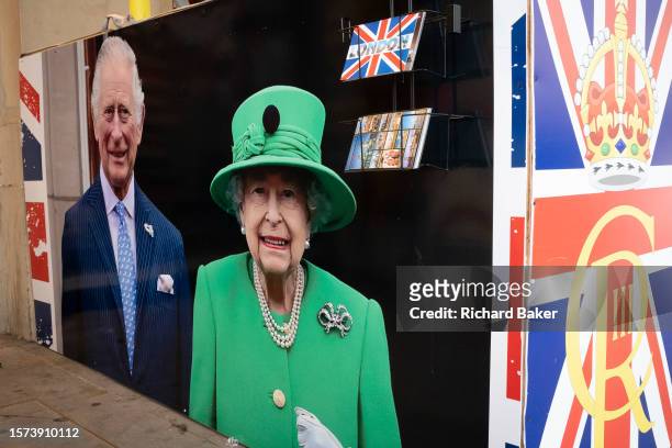 King Charles III and his his late-mother, Queen Elizabeth II are seen on temporary construction hoardings at Piccadilly Circus in the West End, on...