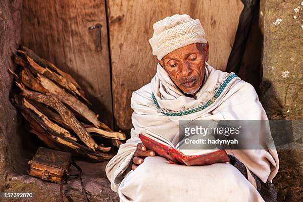 monge ler o livro de oração perto de lalibela de igrejas - povo etíope imagens e fotografias de stock
