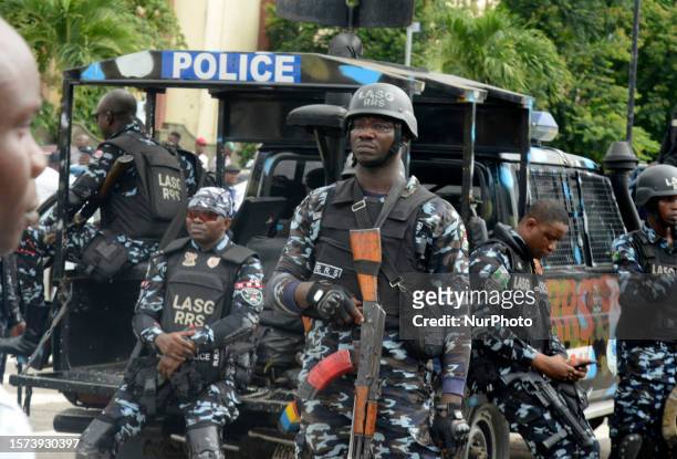 Policemen mount guard as members of Nigeria Labour Congress and Trade Union Congress and Civil Society Group stage a protest over the hardship facing...