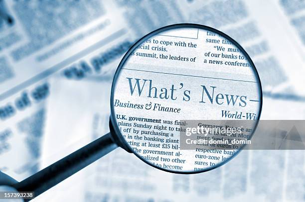 close-up on magnifying glass above wall street journal newspaper, blue - newspaper article stock pictures, royalty-free photos & images
