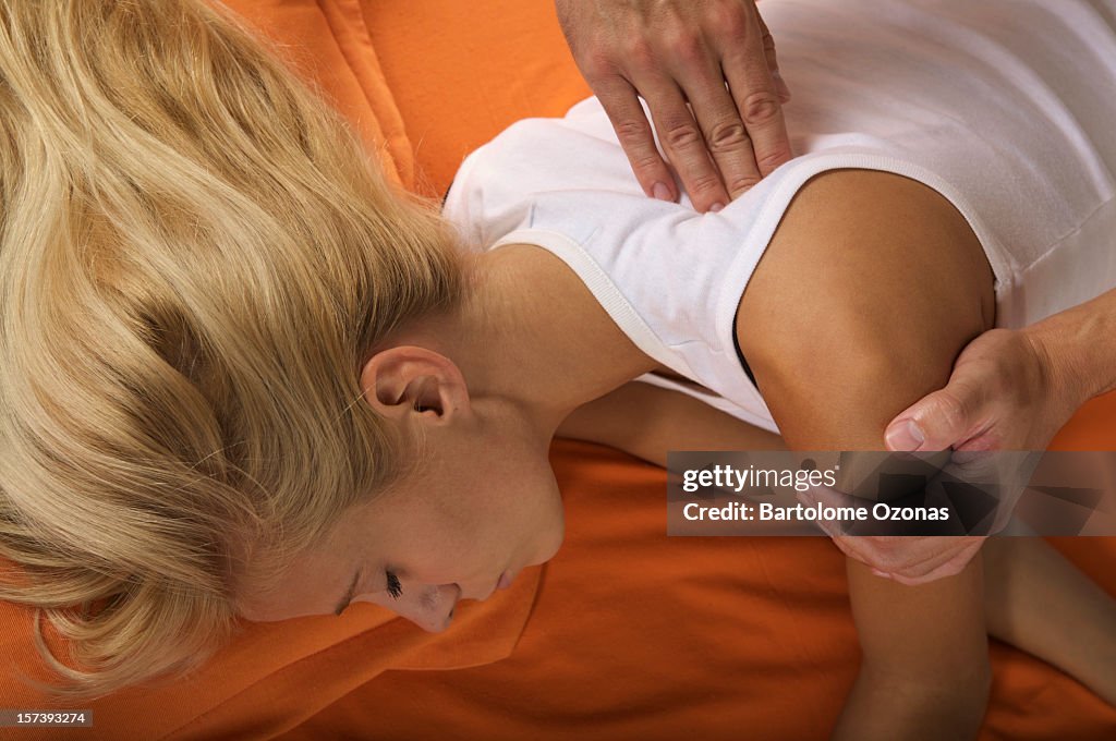 Zen shiatsu therapist applying massage to a female patient