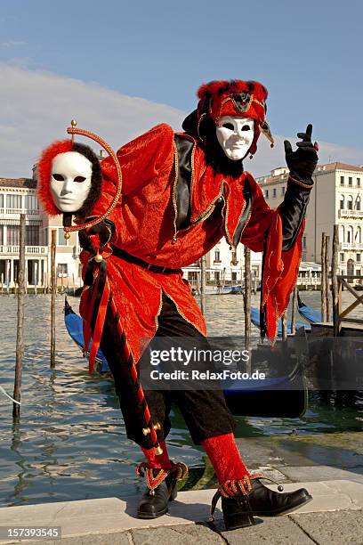 male mask with red harlequin costume at carnival in venice - venetiaans masker stockfoto's en -beelden