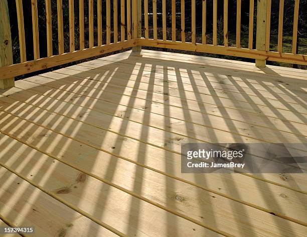 new patio deck floor board surface; pine, railing shadow, sunlight - new deck stock pictures, royalty-free photos & images