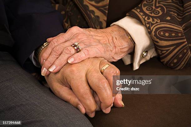 senior married couple holding hands closeup: sixty years of fidelity - 80s wedding stock pictures, royalty-free photos & images