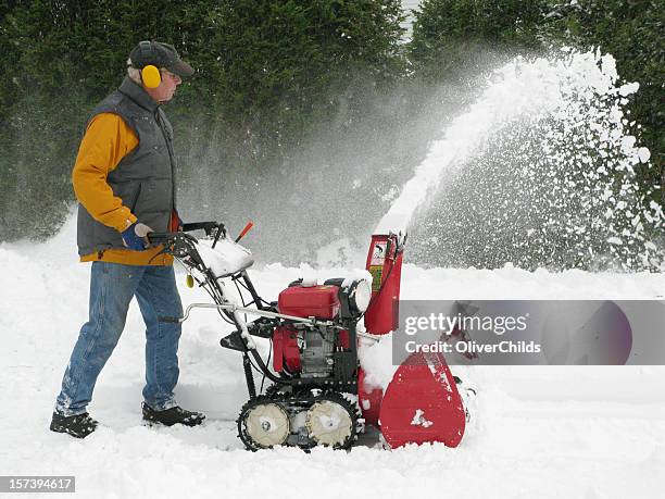 mature man operating a snow blower. - sneeuwmachine stockfoto's en -beelden