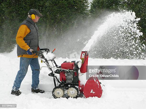 mature man operating a snow blower. - snow blower stock pictures, royalty-free photos & images
