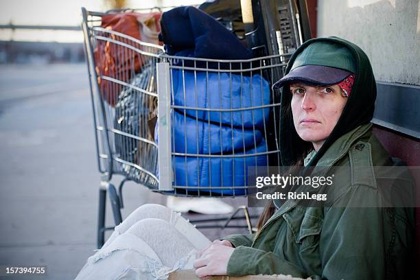 obdachlos frau auf einer straße in der stadt - landstreicher stock-fotos und bilder