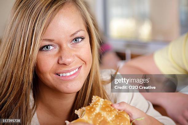 teenage girl eating a cheeseburger - messy cheeseburger stock pictures, royalty-free photos & images