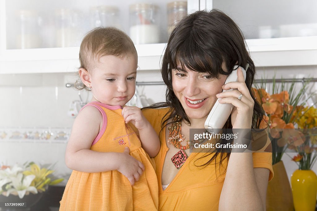 Baby with mother talking in the kitchen