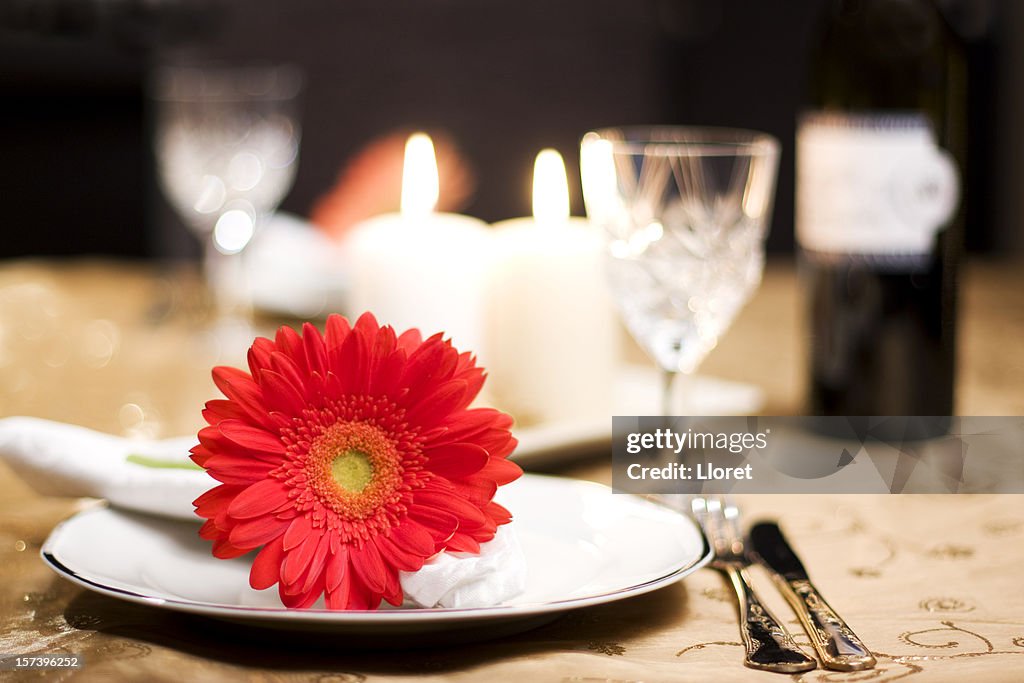 A romantic table for two with a red flower