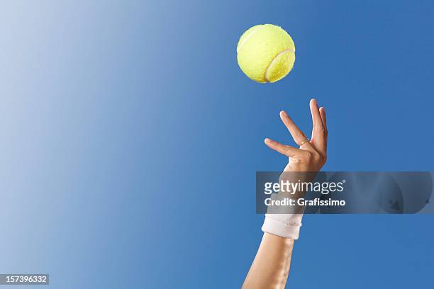 blauer himmel über tennis player - ball werfen stock-fotos und bilder