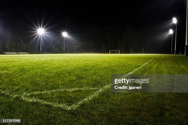fußballplatz bei nacht - flutlicht stock-fotos und bilder
