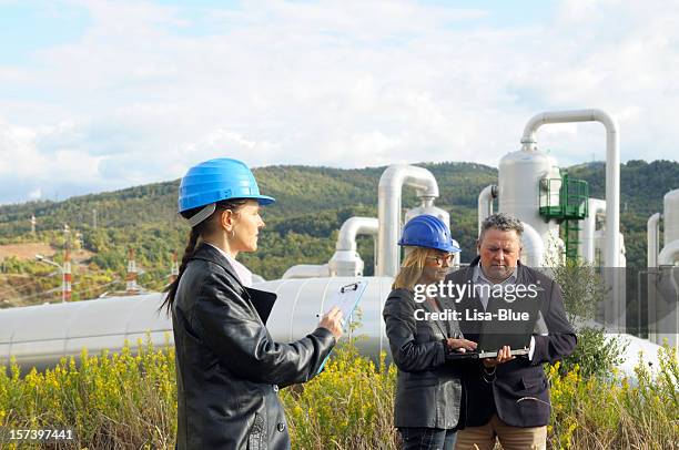 three engineers planning in a geothermal power station. - geothermische centrale stockfoto's en -beelden